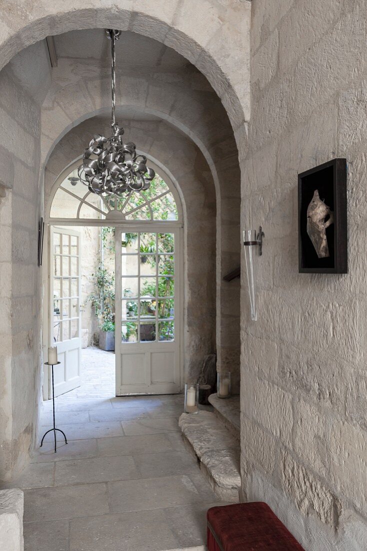 House entrance with stone archway and double doors leading to courtyard