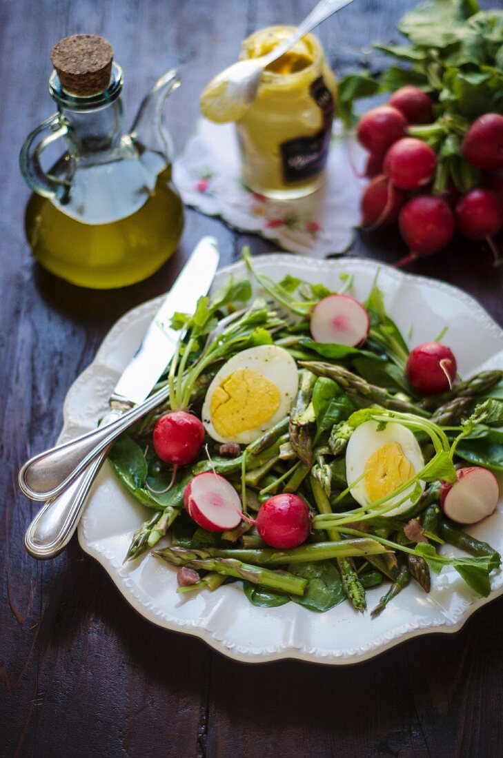 Green asparagus salad with spinach, boiled egg and radishes