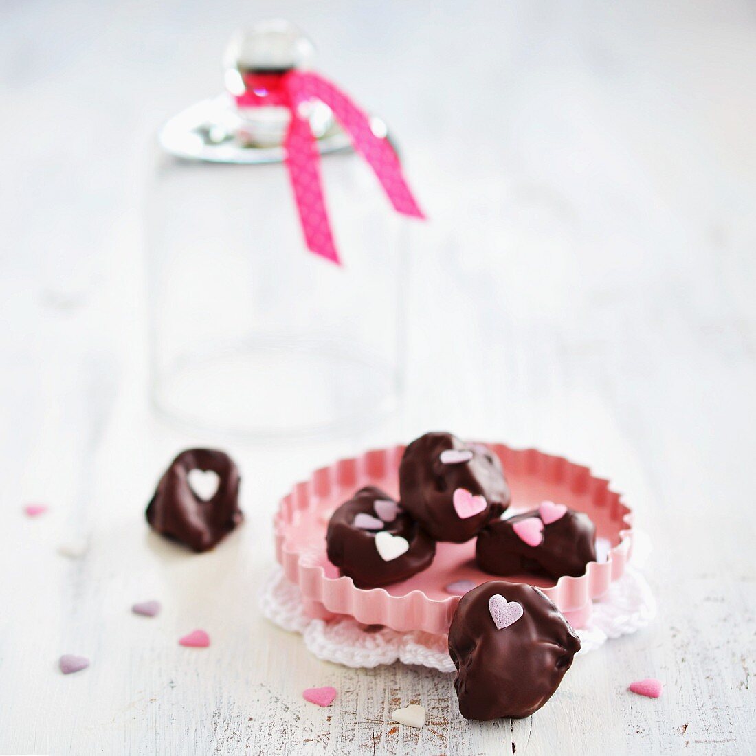 Plums in chocolate decorated with sugar hearts