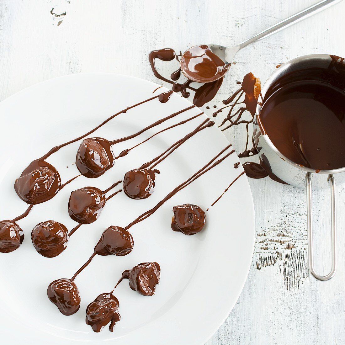 Chocolate-covered plums being made