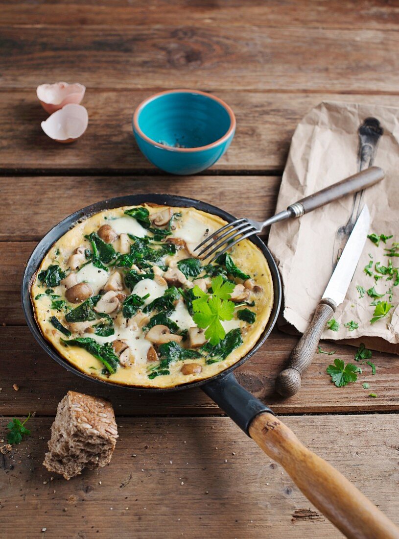 A spinach and mushroom omelette in the pan