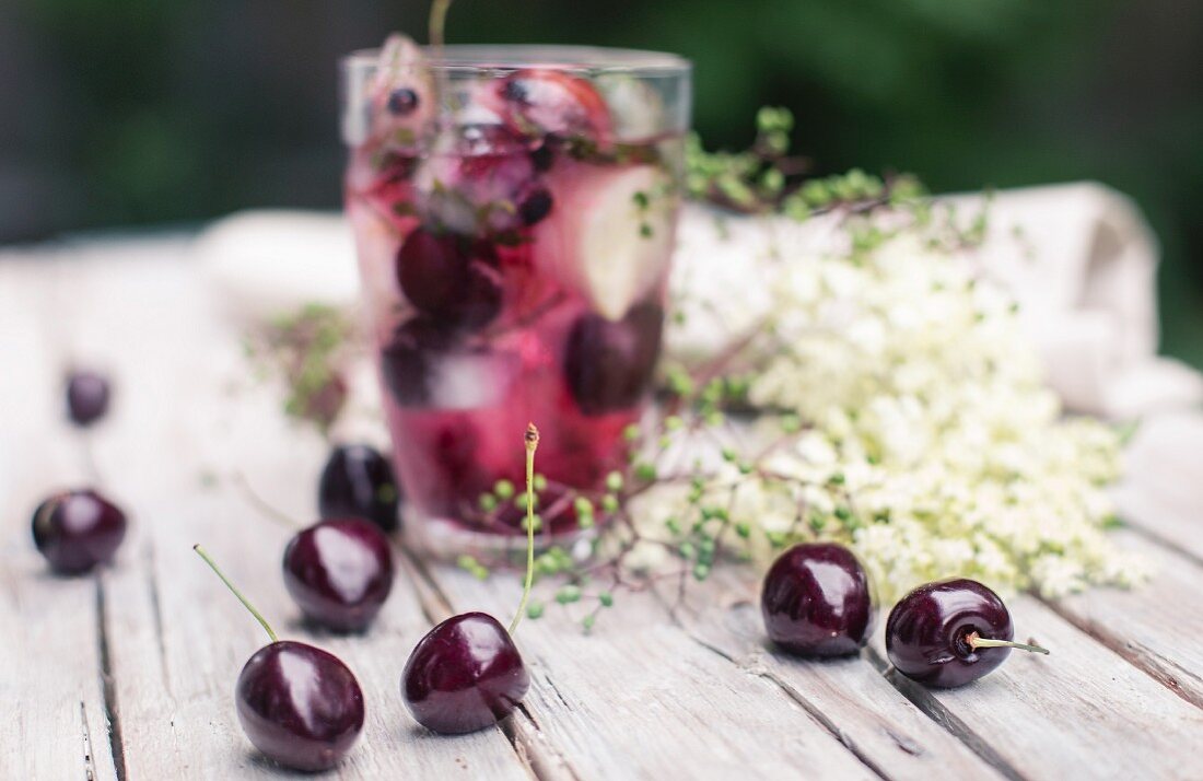 Ice cubes with cherries in a glass of juice