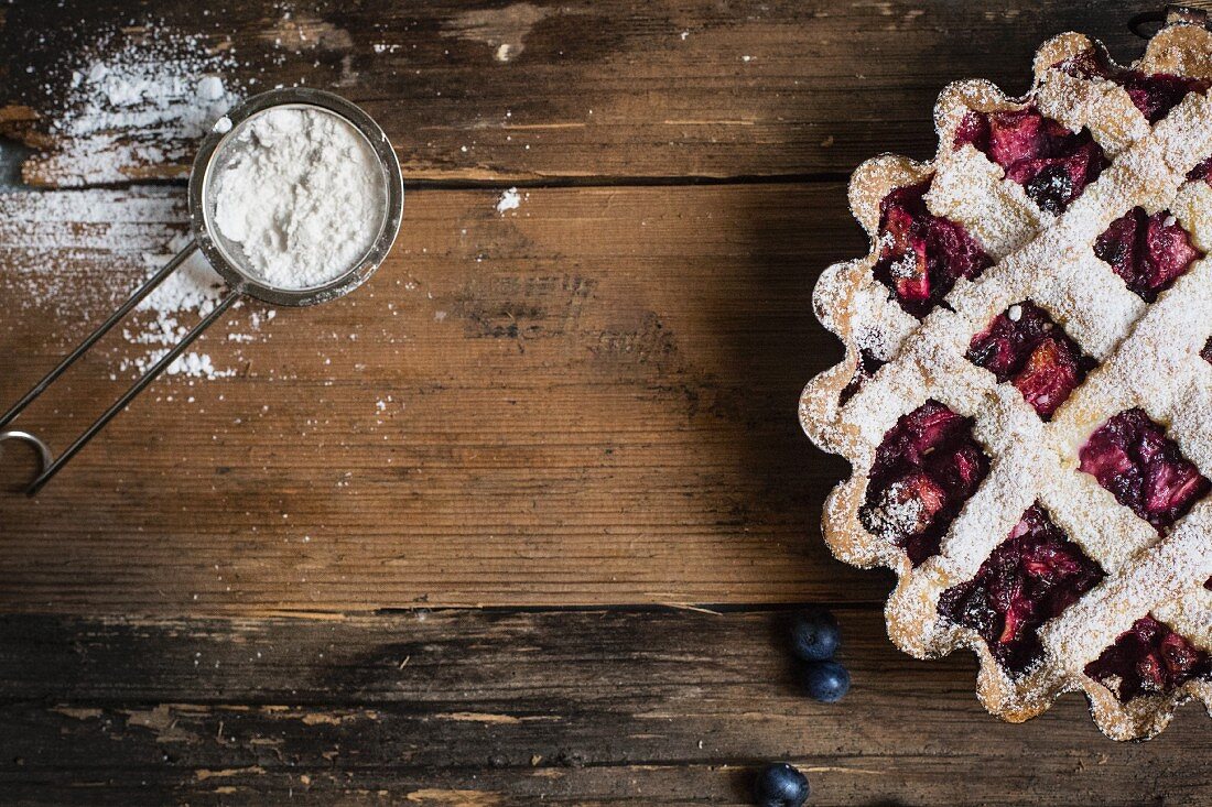 Blueberry tart with a lattice lid and icing sugar