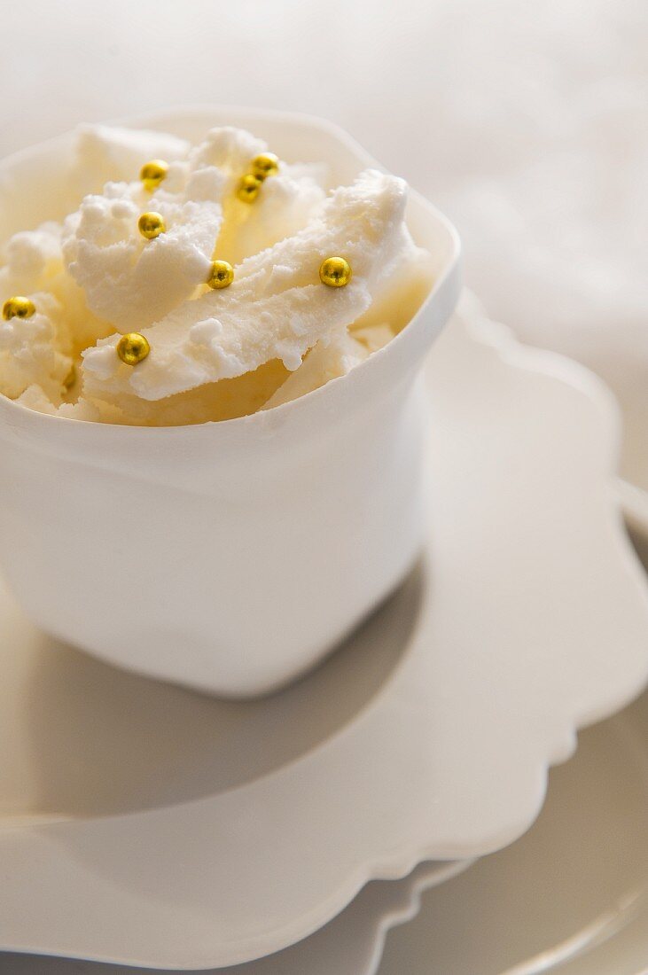 French meringues with golden pearls in a white bowl