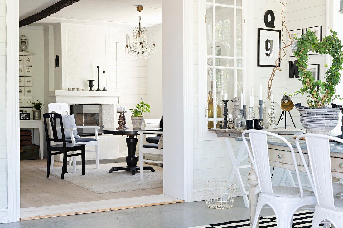 Dining table and retro metal chairs in front of wide, open doorway and view of table with various chairs