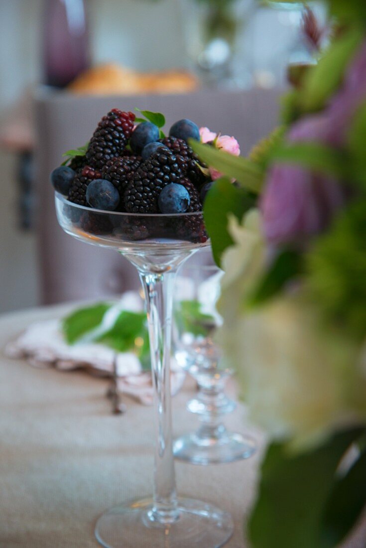 Stielglas mit frischen Blaubeeren und Brombeeren