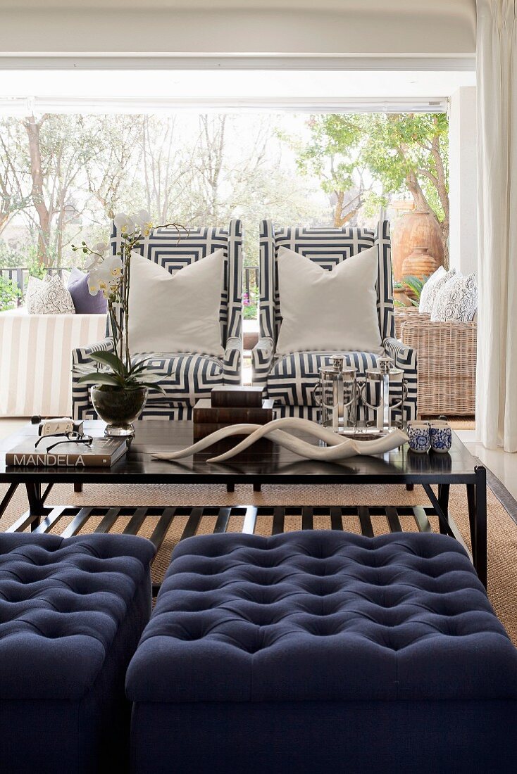 Seating area with blue ottomans and armchairs with geometric-patterned covers