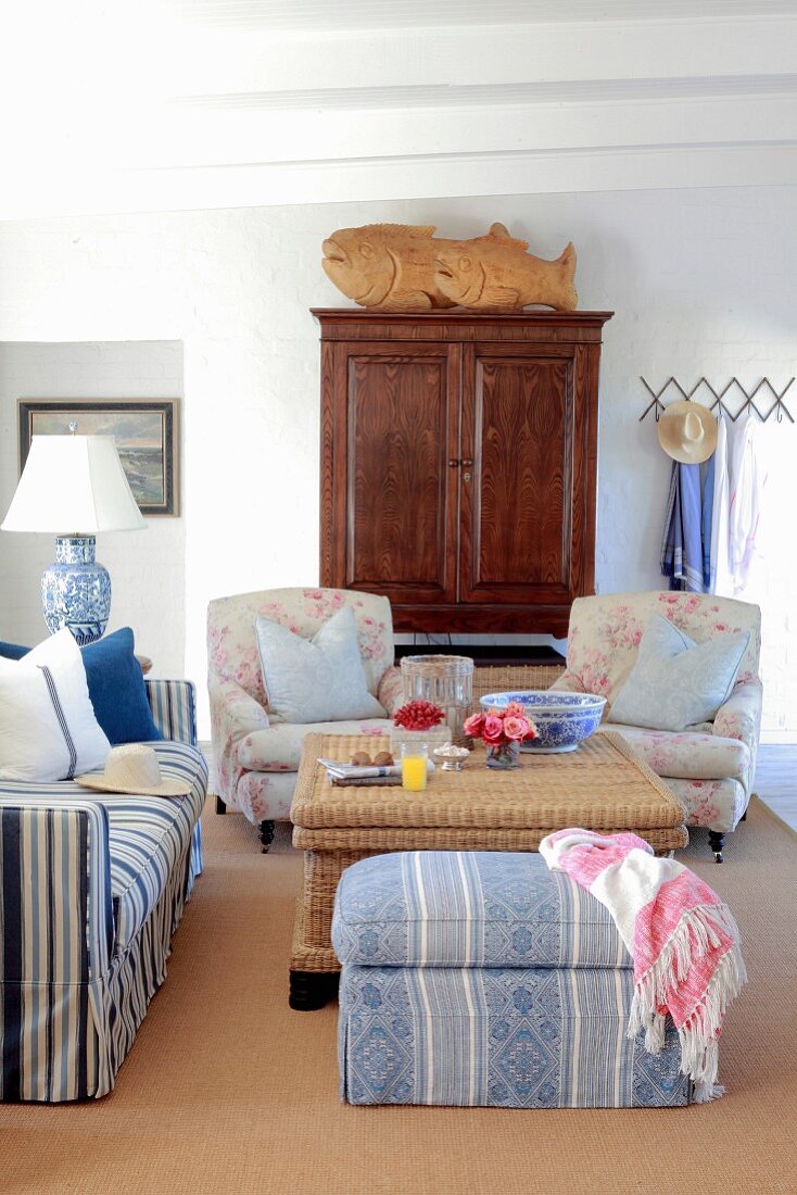 Romantic living room with various upholstered seating and antique wooden cupboard