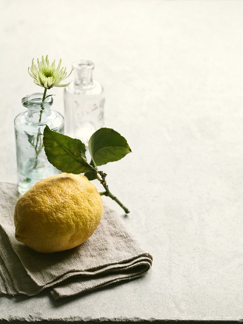 Zitrone mit Stiel und Blättern auf Leinenserviette