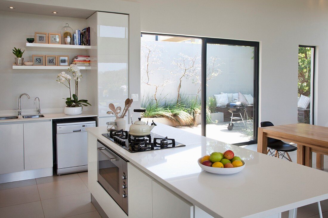 weiße, offene Küche mit Kochinsel, offene Terrassentür