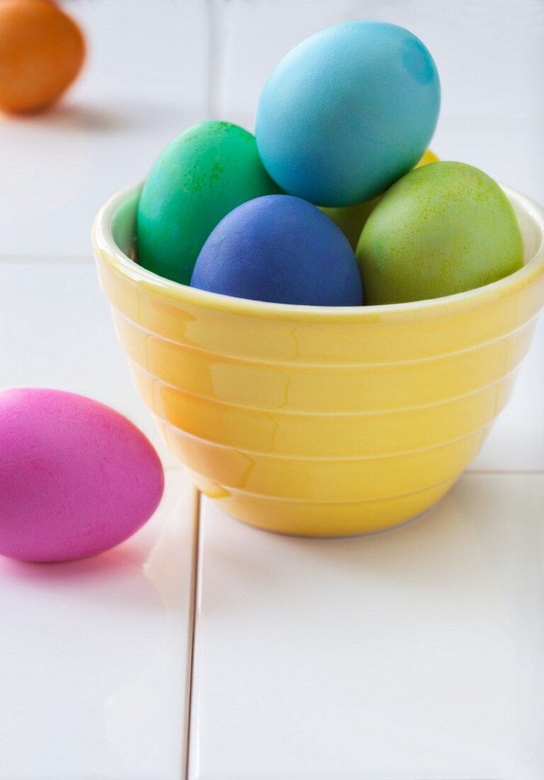 Colourful Easter eggs in a yellow bowl