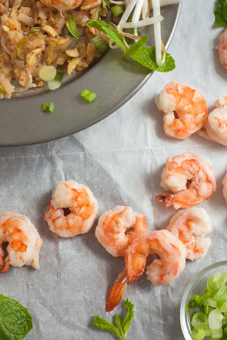 Pad Thai with prawns, bean sprouts, spring rolls and mint (seen from above)