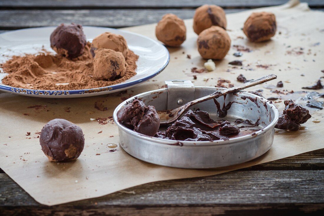 Homemade chocolate truffles with ingredients on an old wooden table