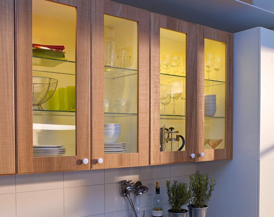Aufgemöbelte Küchenfronten aus Holz und Glas mit Innenbeleuchtung