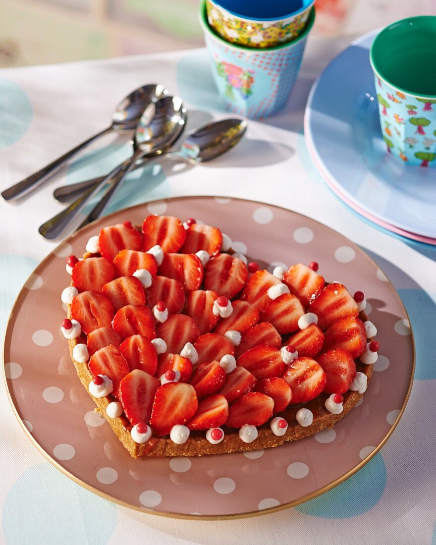 A heart-shaped strawberry tart with cream piping