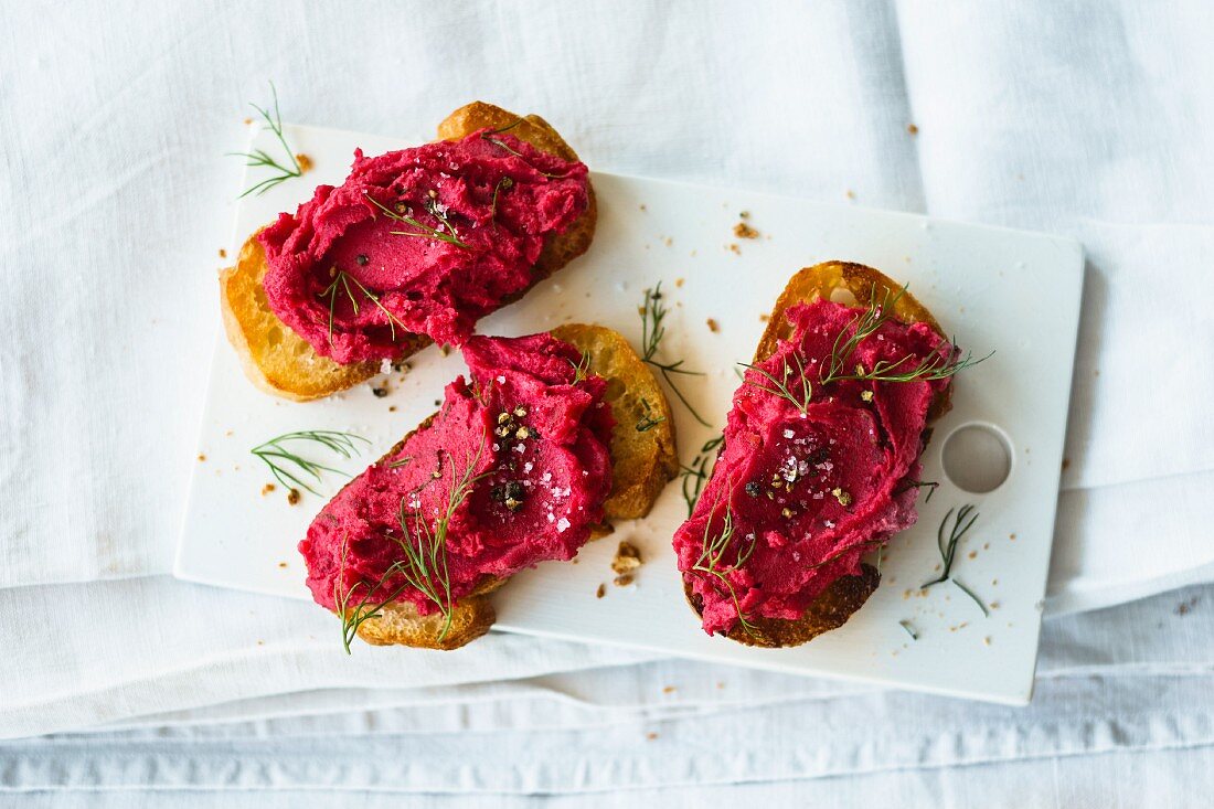 Crostini topped with beetroot and potato paste