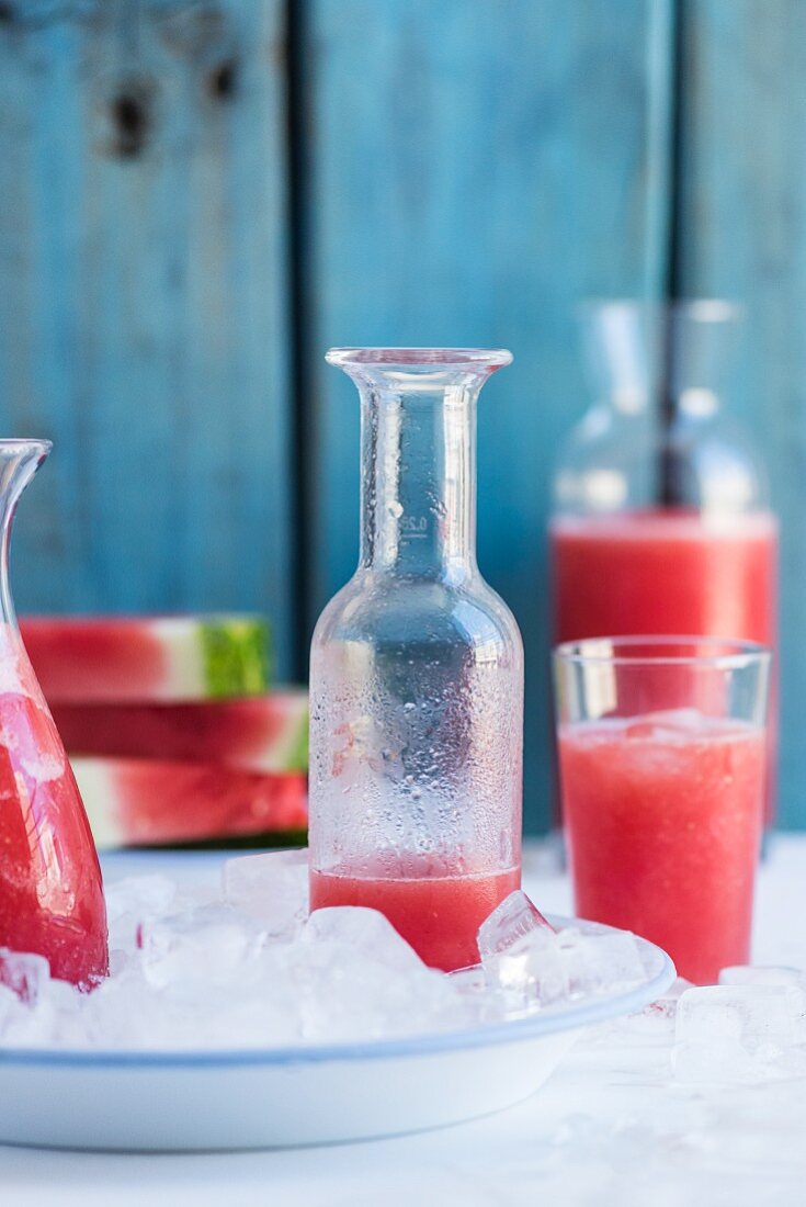 Watermelon lemonade in bottles and a glass