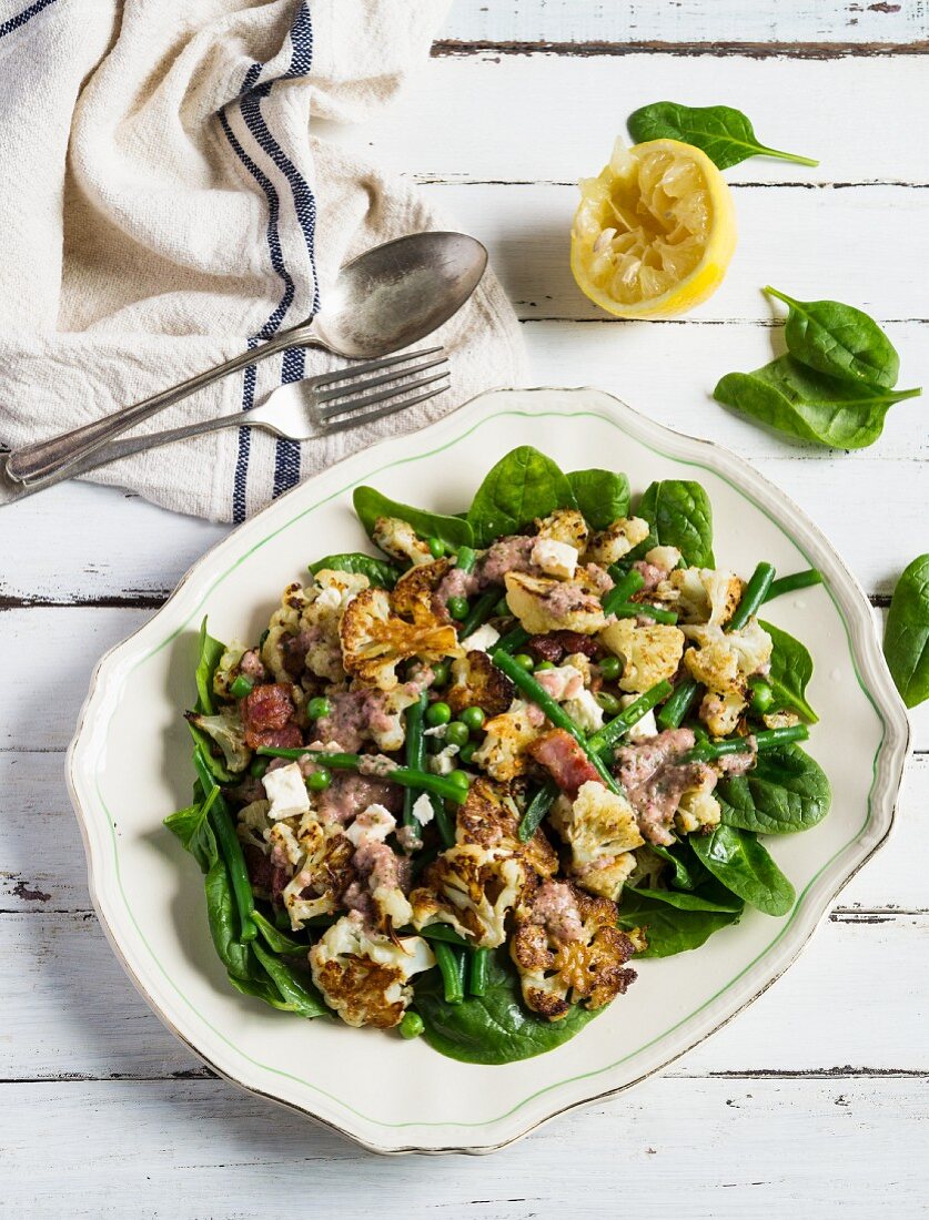 Cauliflower and spinach salad with green beans, peas and bacon