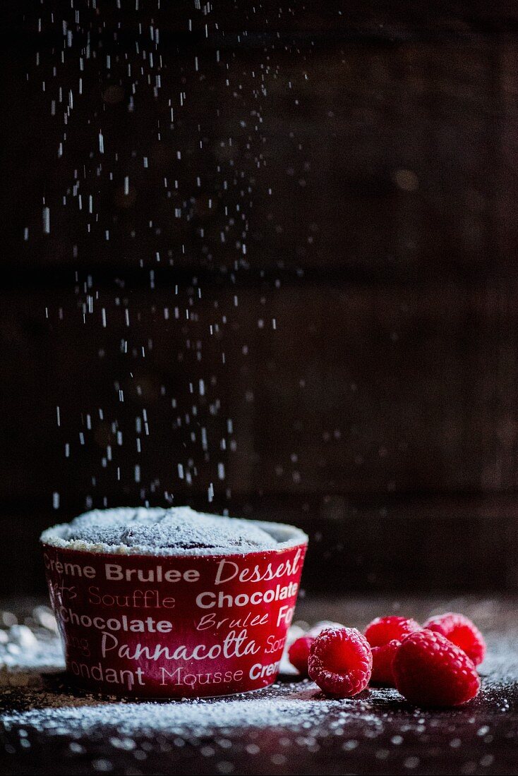 Schokoladenpudding mit Puderzucker und Himbeeren