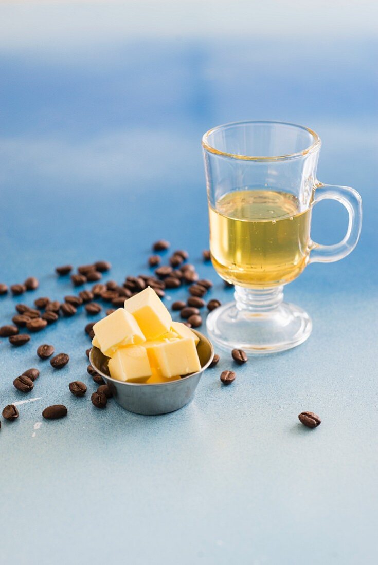 Öl im Glas mit Butterwürfel und Kaffeebohnen