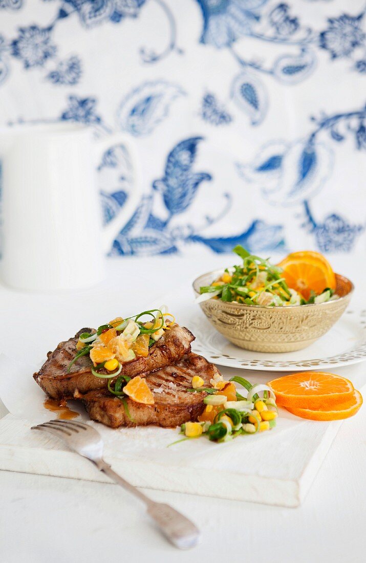 Pork chops in a spicy clementine and avocado salsa with sweetcorn