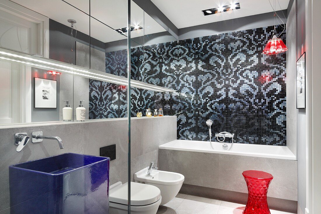 Designer bathroom in shades of grey with red accents