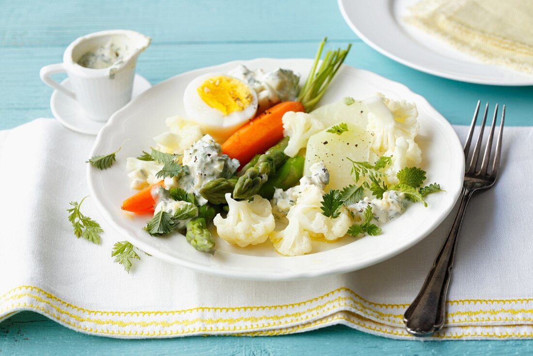 Colourful vegetables with hard boiled eggs and a herb and quark sauce
