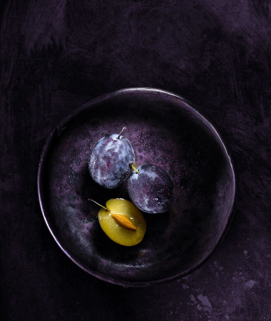 Fresh plums in a metal bowl