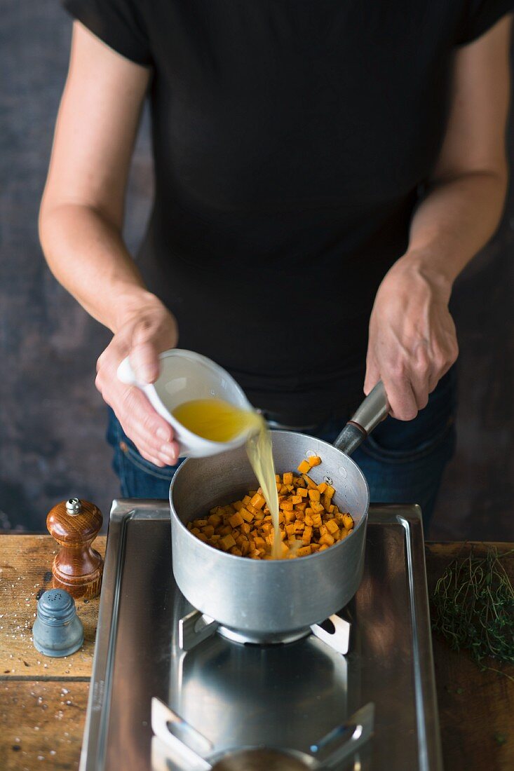 Fried diced sweet potatoes being quenched with orange juice