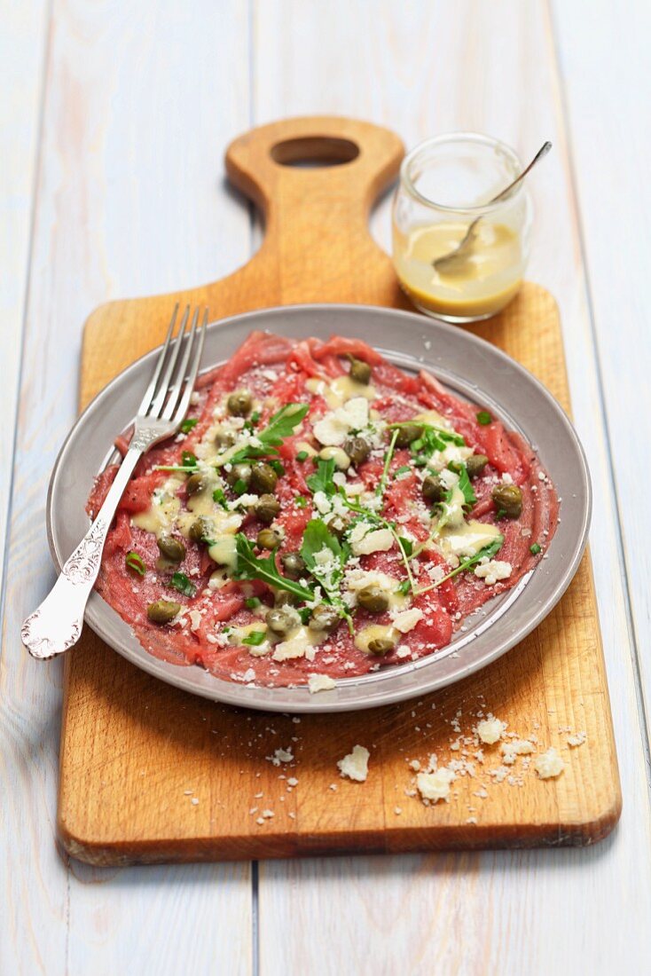 Beef carpaccio with mustard dressing, capers and Parmesan cheese