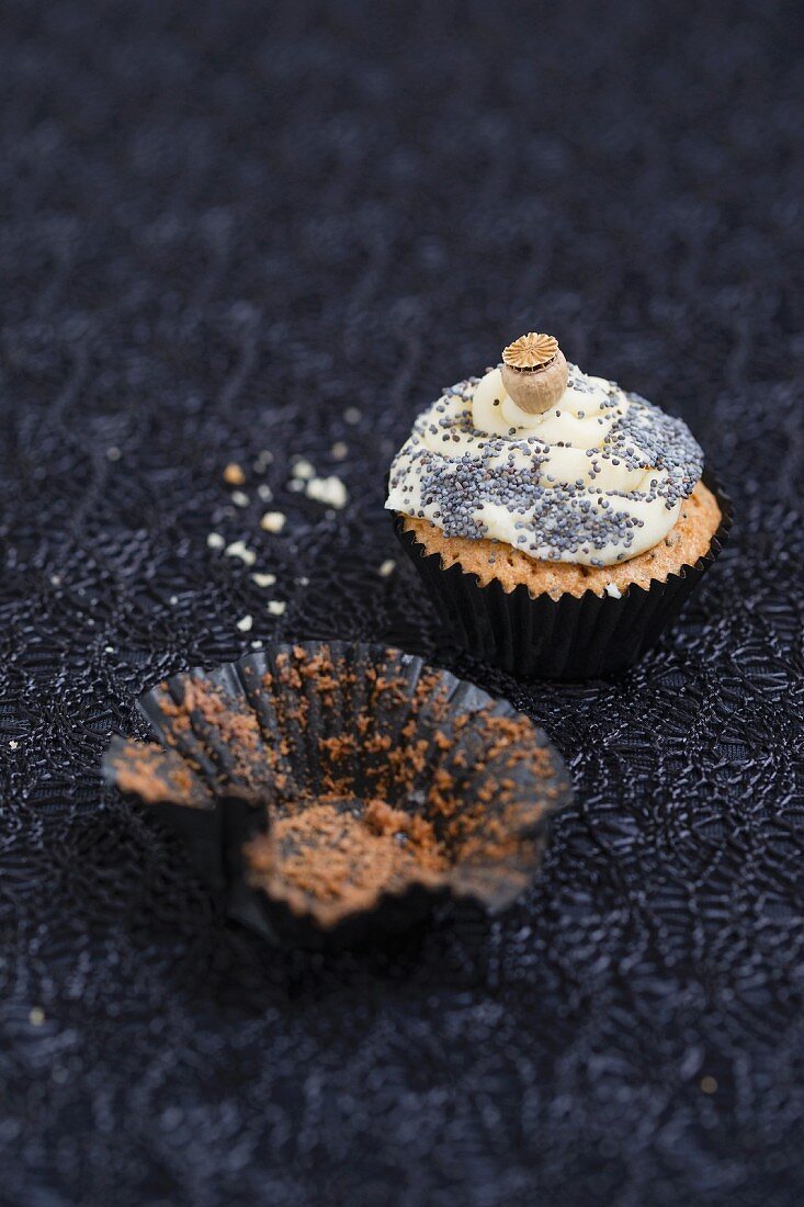 A mini cupcake with a poppyseed and vanilla topping
