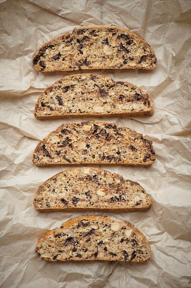 A row of biscotti on a piece of brown paper (seen from above)