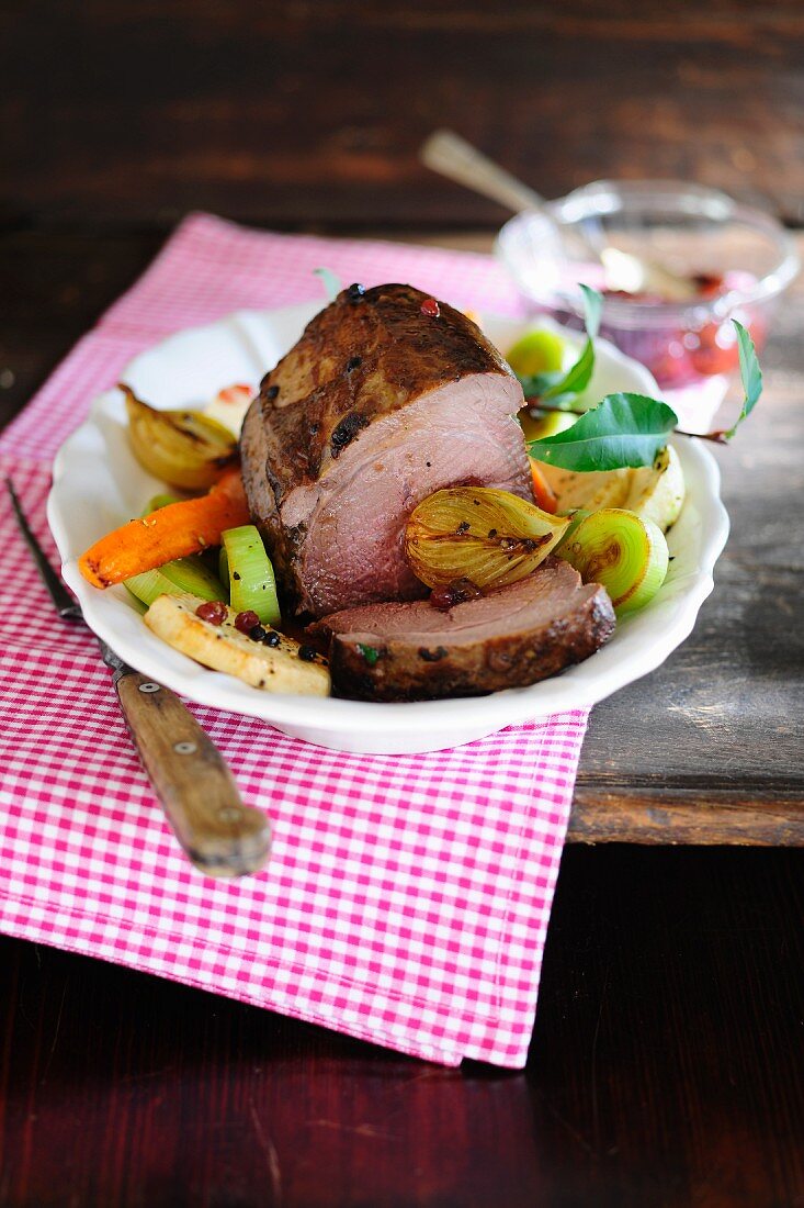 Roasted wild boar with vegetables and cranberries