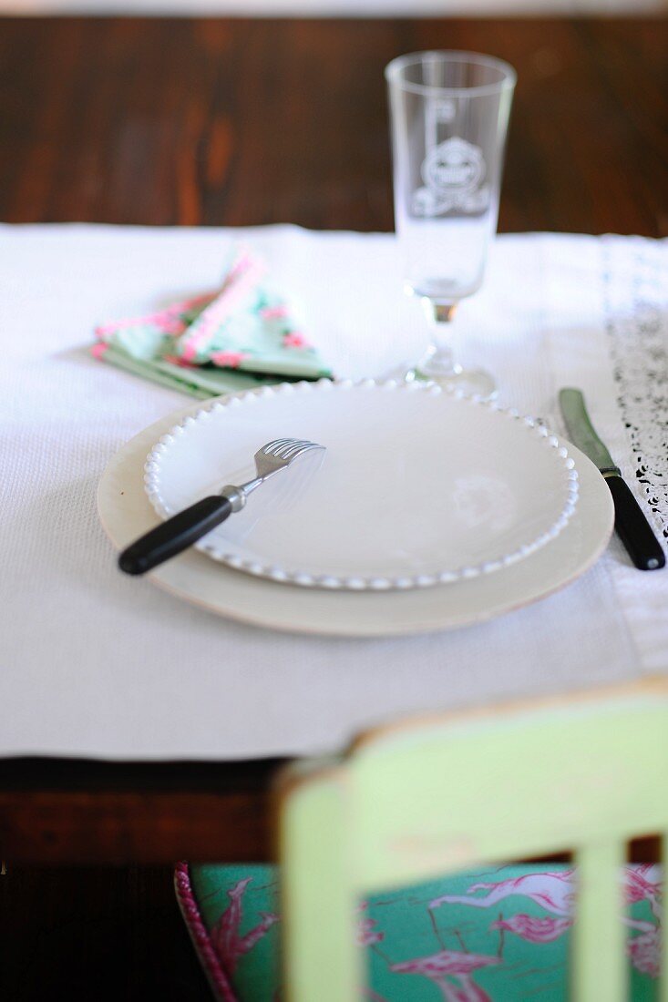 A place setting on a rustic table with a white tablecloth