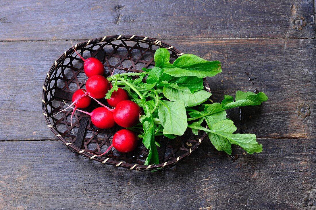 Fresh radishes in a basket (seen from above)