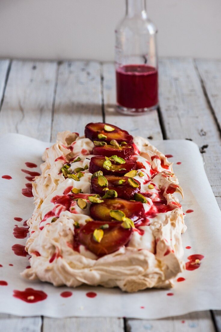 Pavlova with plums and pistachios