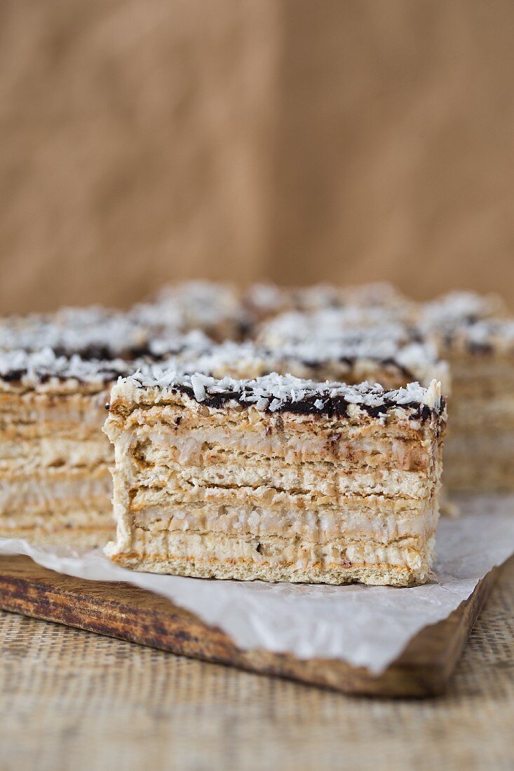 A layered sponge cake with walnut and coconut cream glazed with ganache