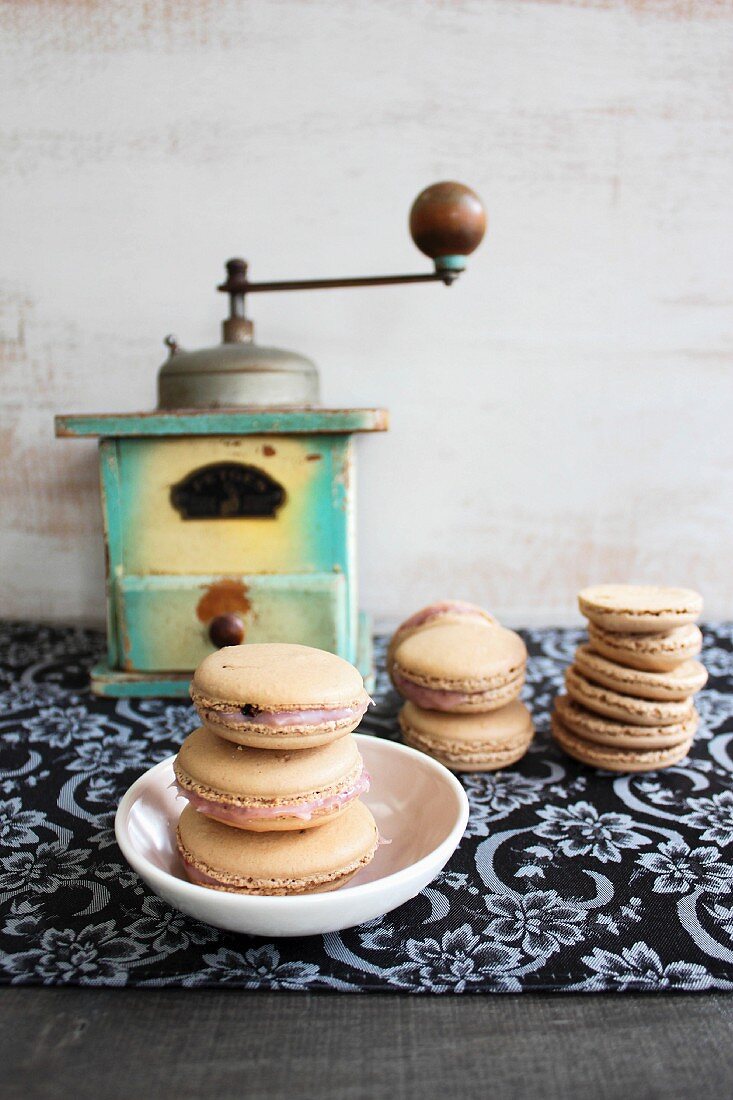 Macaroons in front of an old coffee grinder