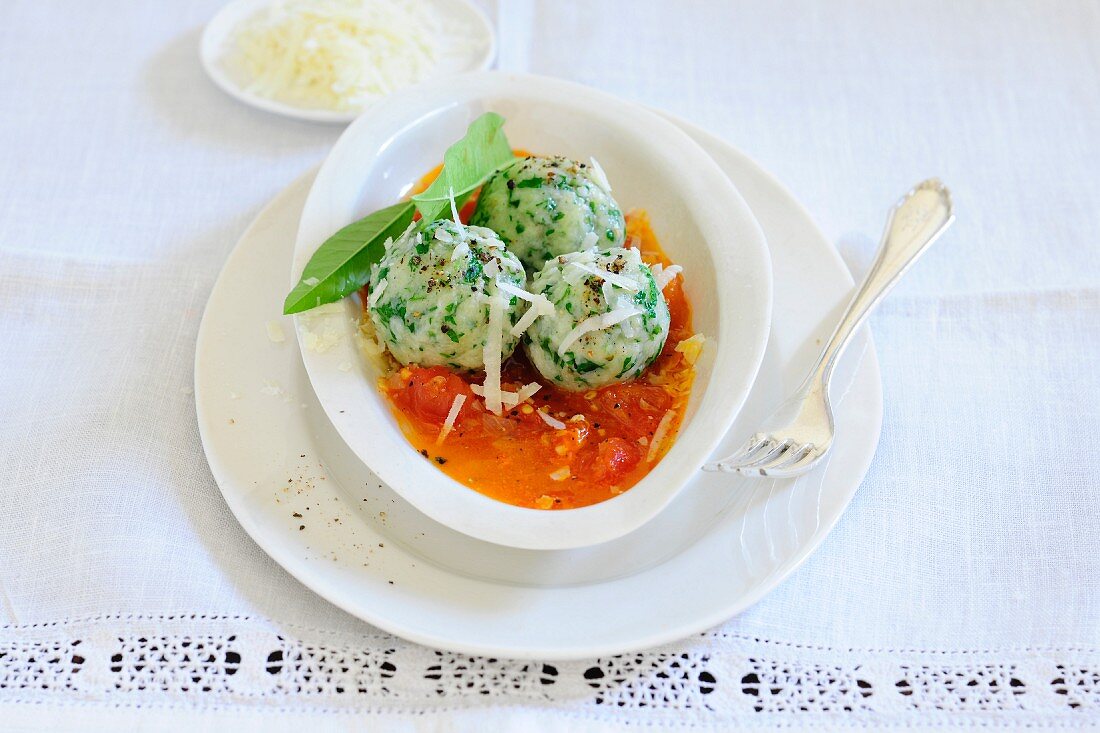 Wild garlic dumplings with tomato sauce and grated cheese
