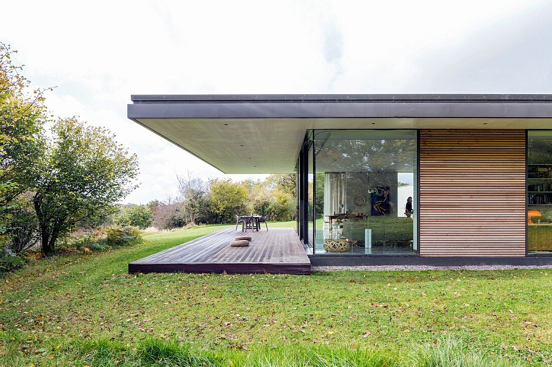 Modern house with roof projecting over terrace in morning light