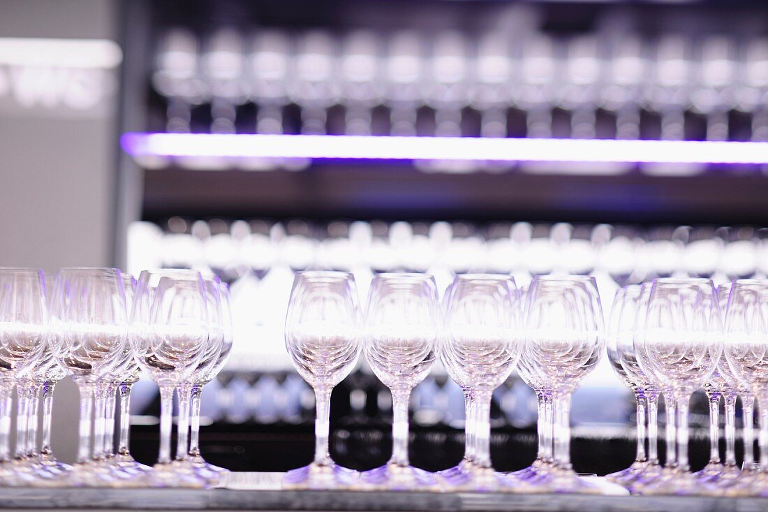 A row of empty wine glasses on a restaurant counter