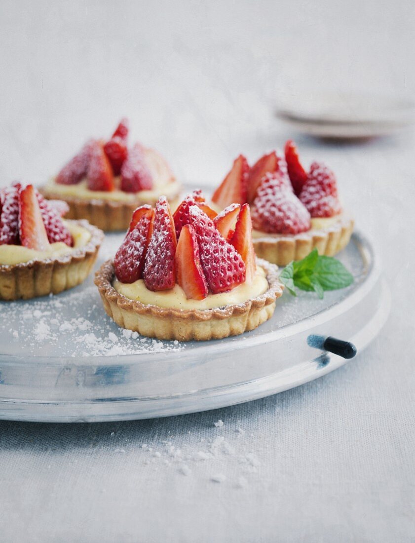 Strawberry tartlets on a cake plate