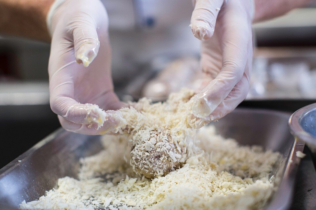 Bread being rolled in Parmesan