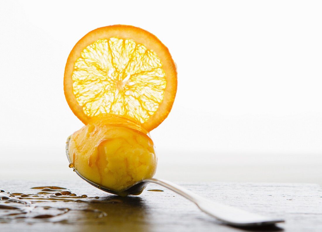 Ice cream with Cointreau and a candied orange slice on a spoon