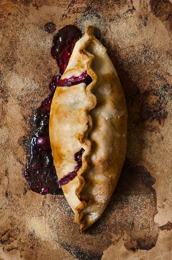 An apple and blueberry turnover on a baking stone