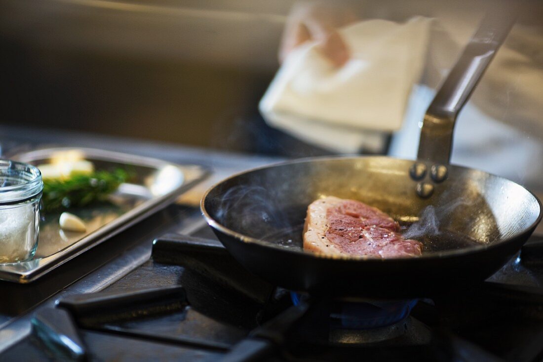 Koch bereitet Steak in der Grossküche zu