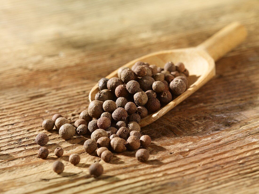 Allspice berries on a wooden scoop