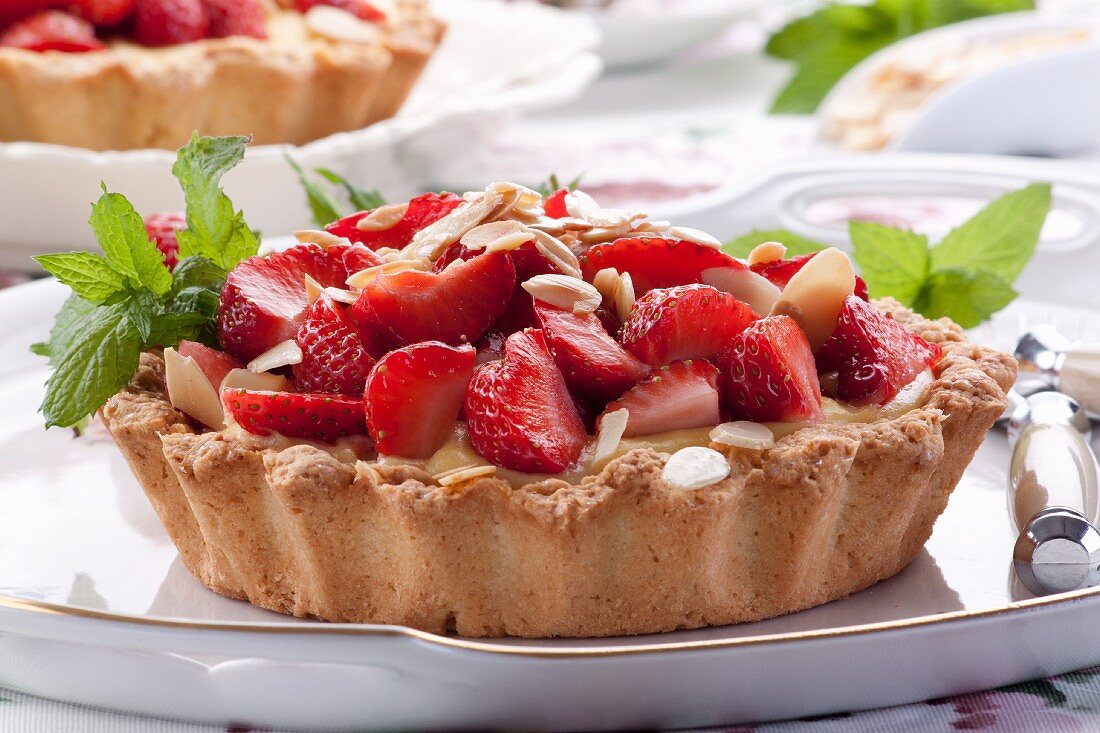 Strawberry tartlets with pudding and almonds