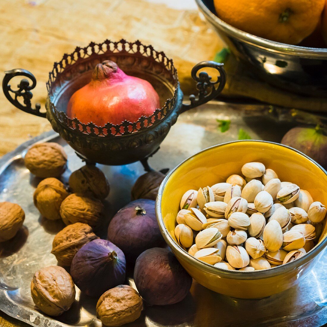 An oriental arrangement of pistachios, pomegranates, walnuts and figs