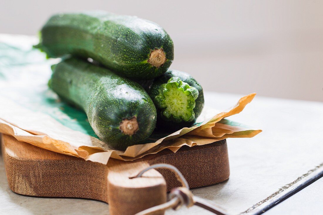 Fresh courgettes with paper on a chopping board